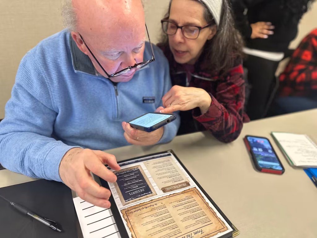 A person uses a smarphone camera to read a restaurant menu.