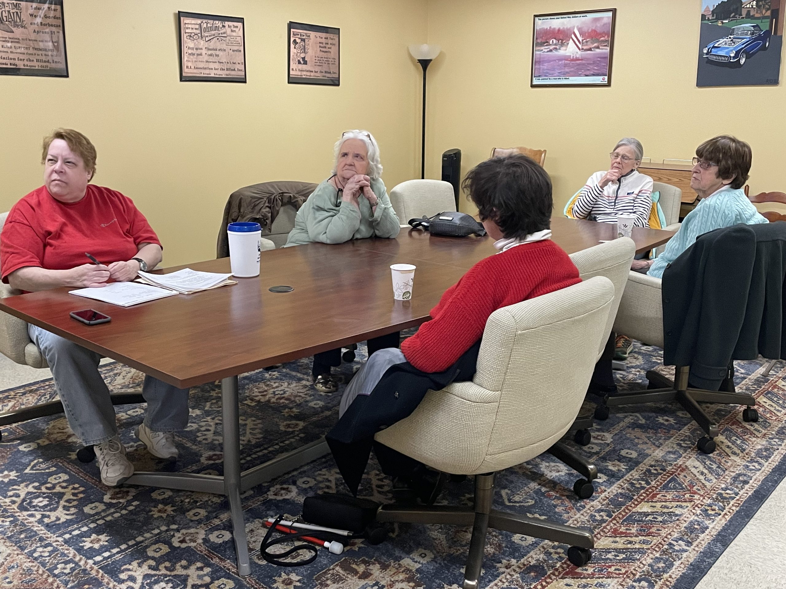 A group of people sitting around a conference room table having a discussion.