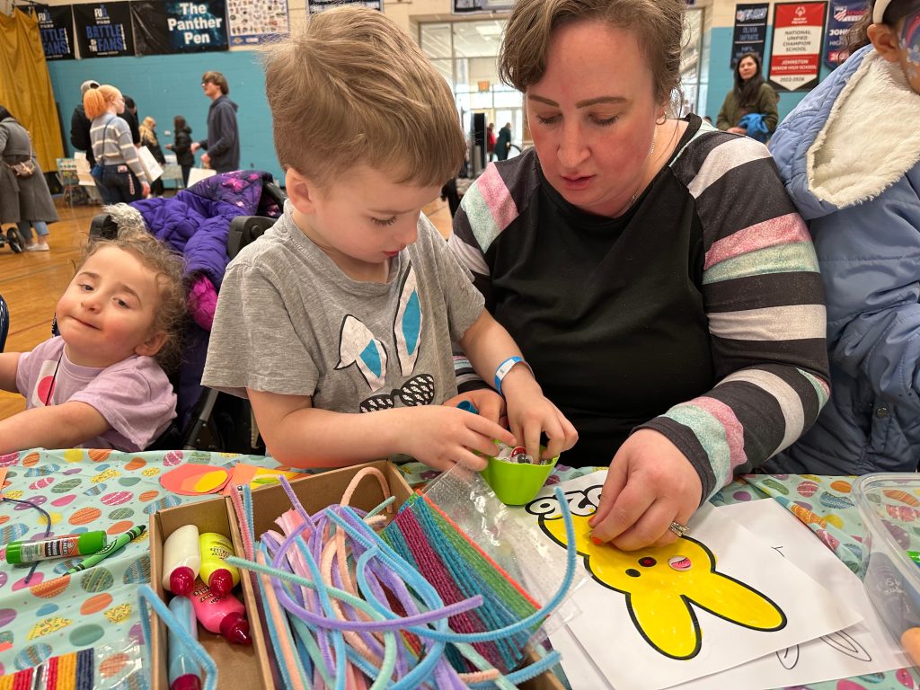 A boy and his mother look at what is inside a plastic egg