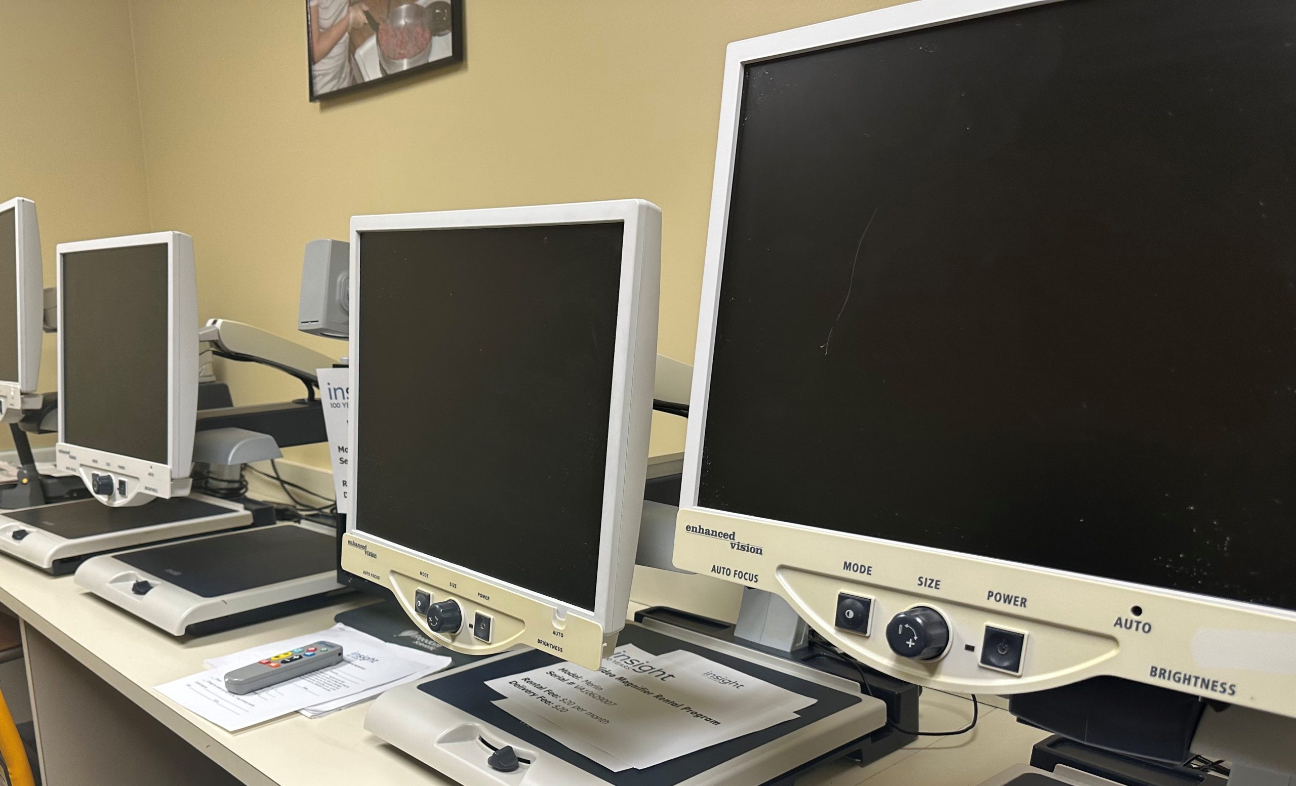 Three video magnifiers in a row on a table.